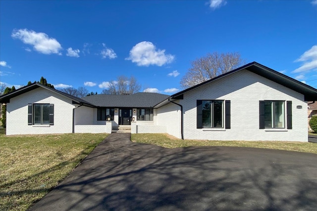 ranch-style home with brick siding and a front lawn