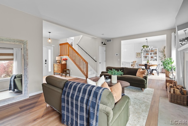 living room with stairs, wood finished floors, and baseboards