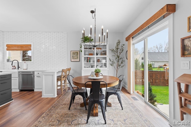 dining space featuring light wood-style flooring, a chandelier, and healthy amount of natural light