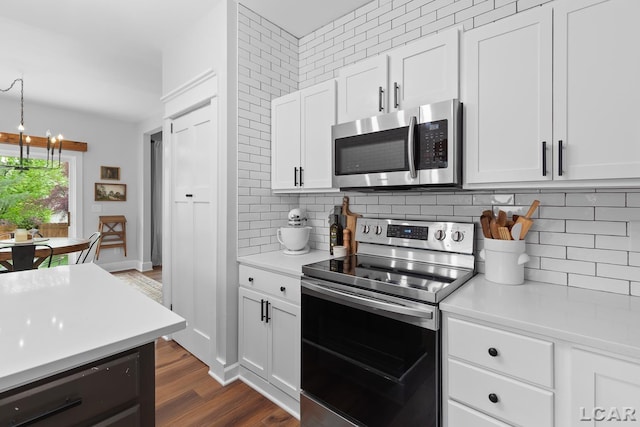 kitchen featuring appliances with stainless steel finishes, light countertops, decorative backsplash, and white cabinets