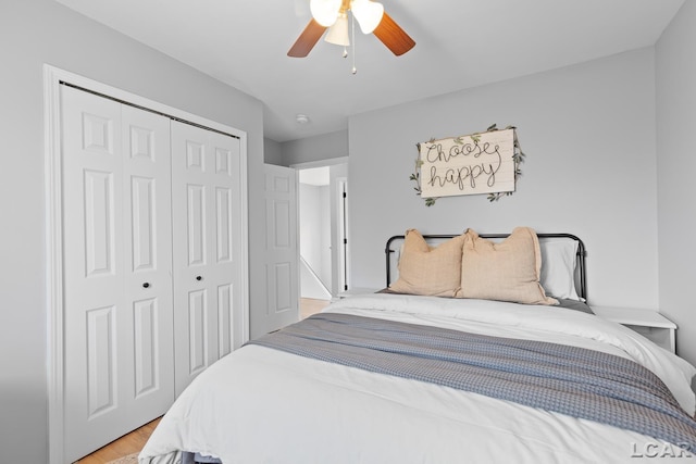 bedroom featuring a closet, light wood finished floors, and ceiling fan