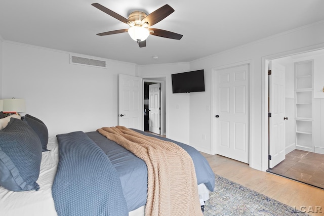 bedroom with crown molding, wood finished floors, and a ceiling fan