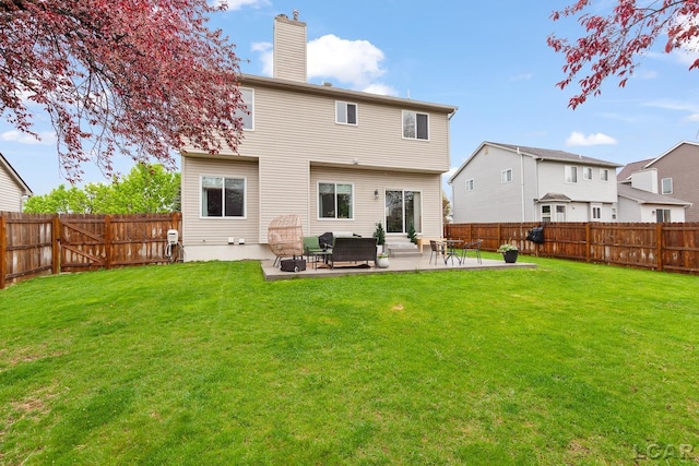 rear view of property featuring a chimney and a patio