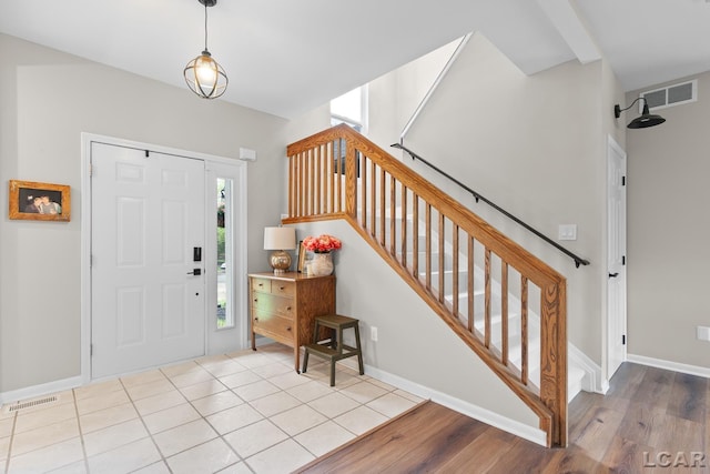 foyer featuring stairway, wood finished floors, and baseboards