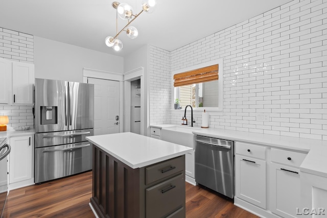 kitchen with appliances with stainless steel finishes, a sink, decorative backsplash, and light countertops