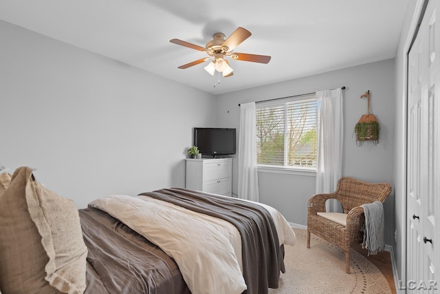 bedroom with a closet, baseboards, and a ceiling fan
