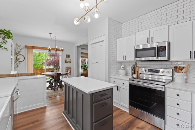 kitchen featuring appliances with stainless steel finishes, a chandelier, decorative backsplash, and white cabinets