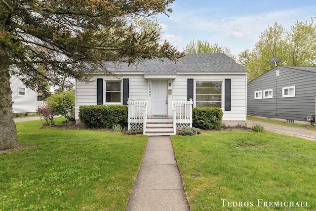 bungalow-style home with a front lawn and a shingled roof