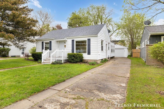 bungalow-style home with roof with shingles, a detached garage, and an outdoor structure