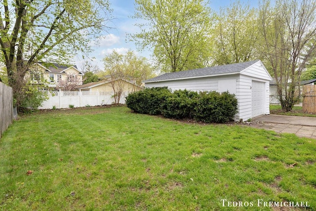 view of yard featuring an outdoor structure and a detached garage