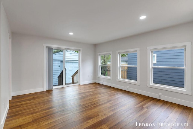 empty room featuring hardwood / wood-style floors, baseboards, healthy amount of natural light, and recessed lighting
