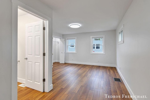 empty room with wood-type flooring and baseboards