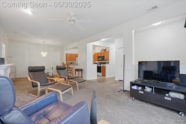 16490 Norfolk Dr, Macomb, MI 48044 - living area with light colored carpet, a chandelier, a ceiling fan, and baseboards