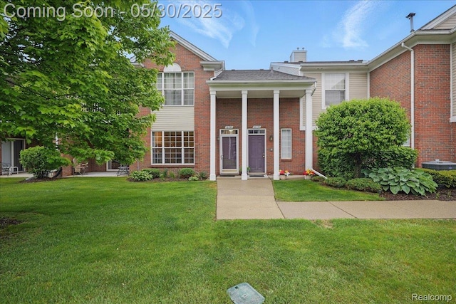 16490 Norfolk Dr, Macomb, MI 48044 - neoclassical home with a front yard, a chimney, and brick siding