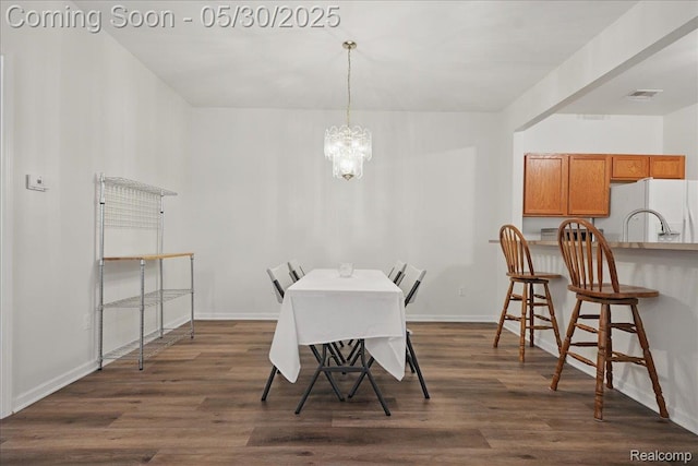 16490 Norfolk Dr, Macomb, MI 48044 - dining room featuring dark wood finished floors, a chandelier, and baseboards