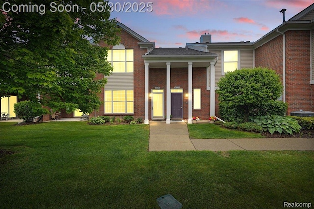 16490 Norfolk Dr, Macomb, MI 48044 - view of front of home featuring a yard, a chimney, and brick siding