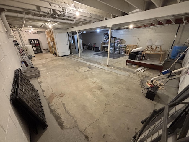 1335 N Sherman Rd, Ludington, MI 49431 - unfinished basement featuring water heater, concrete block wall, and a water pressure tank