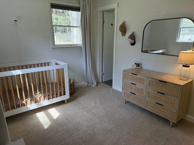 1335 N Sherman Rd, Ludington, MI 49431 - bedroom featuring light colored carpet, baseboards, and a crib