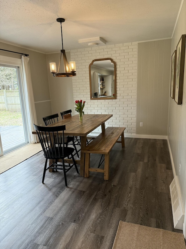 1335 N Sherman Rd, Ludington, MI 49431 - dining area with a chandelier, dark wood finished floors, a textured ceiling, crown molding, and baseboards