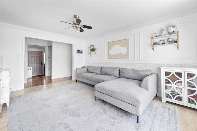 living area with wood finished floors and ceiling fan