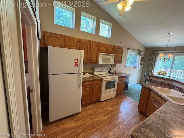 4522 Willow View Ct, Howell, MI 48843 - kitchen with white appliances, a sink, dark countertops, wood finished floors, and brown cabinetry