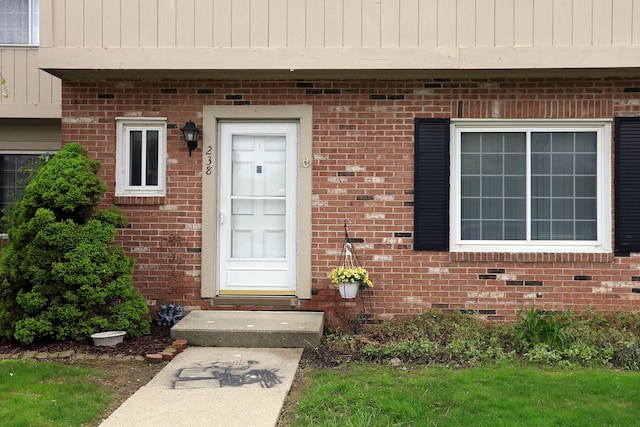 doorway to property with brick siding
