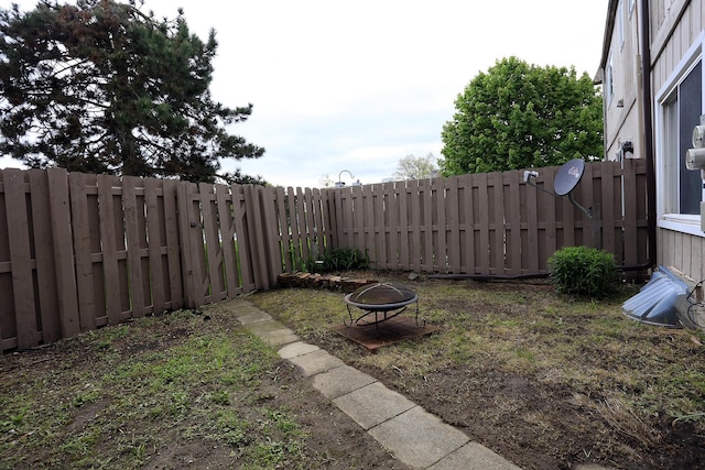 fenced backyard featuring a fire pit