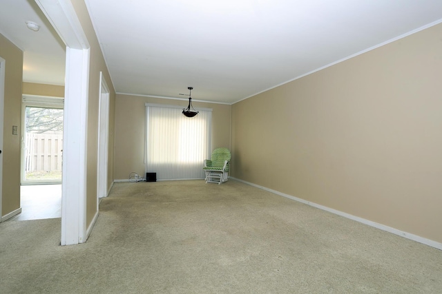 spare room with carpet, baseboards, and crown molding