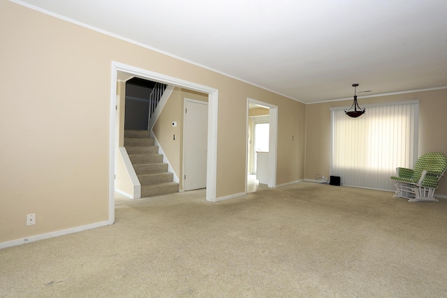 spare room with carpet, ornamental molding, stairs, and baseboards