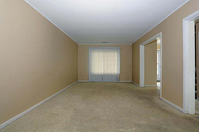 spare room featuring ornamental molding, baseboards, and carpet flooring