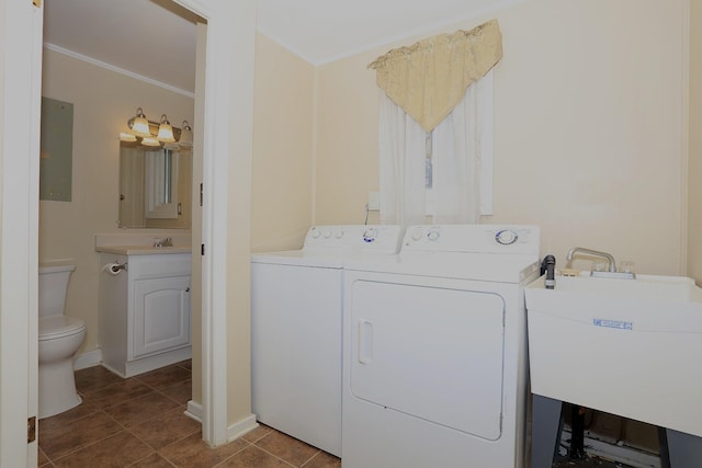 laundry room with a sink, tile patterned floors, crown molding, baseboards, and separate washer and dryer