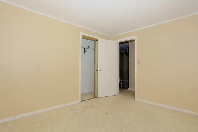unfurnished bedroom featuring crown molding, carpet flooring, baseboards, and a closet