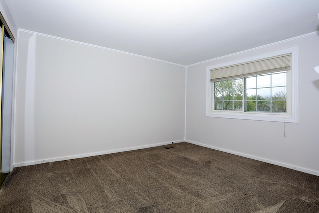 unfurnished room with dark carpet, crown molding, and baseboards