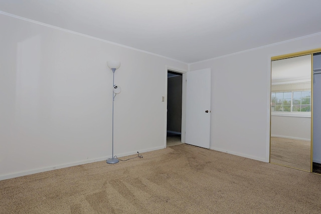 carpeted empty room with ornamental molding and baseboards