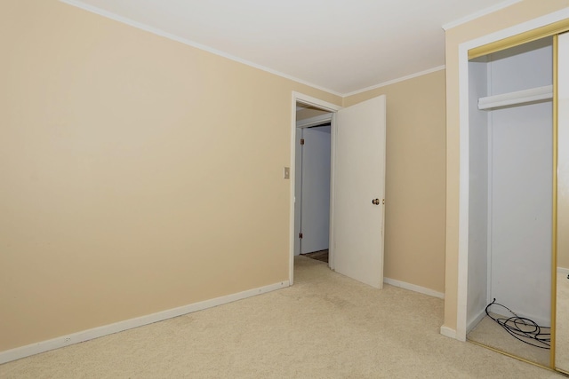unfurnished bedroom featuring a closet, ornamental molding, carpet floors, and baseboards