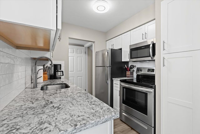 8080 Farnum Ct, Warren, MI 48093 - kitchen with stainless steel appliances, a sink, decorative backsplash, white cabinetry, and light stone countertops