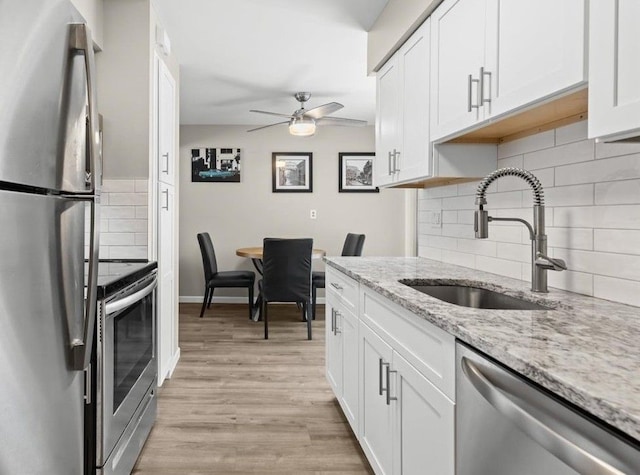 8080 Farnum Ct, Warren, MI 48093 - kitchen with appliances with stainless steel finishes, a sink, ceiling fan, white cabinetry, and light wood-style flooring