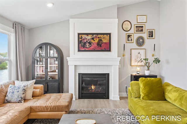 living room with wood finished floors, a fireplace, vaulted ceiling, and recessed lighting