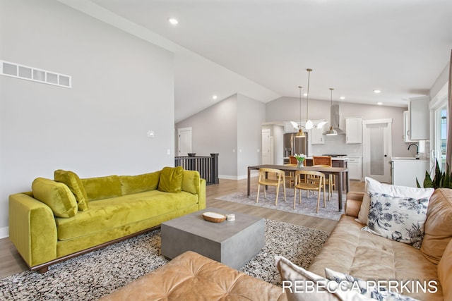 living room with light wood-type flooring, lofted ceiling, baseboards, and recessed lighting