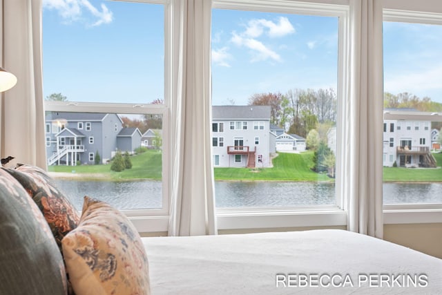 bedroom featuring a water view and a residential view