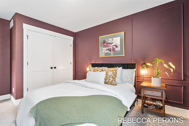 carpeted bedroom featuring baseboards and a closet