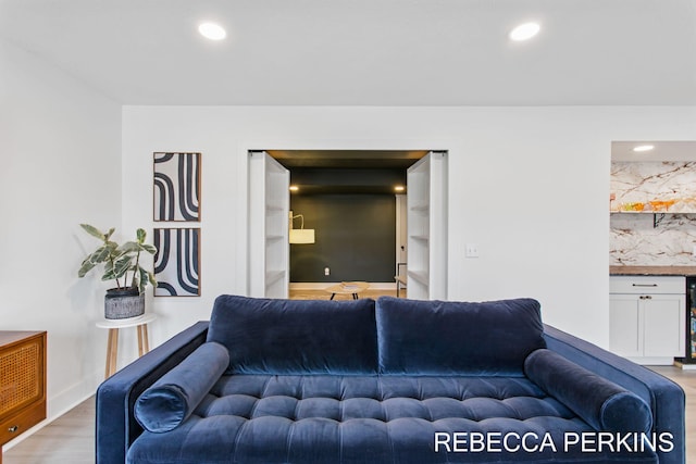 living room featuring light wood finished floors, recessed lighting, and baseboards