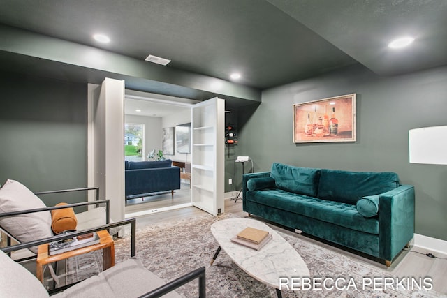 living room featuring wood finished floors, recessed lighting, and baseboards