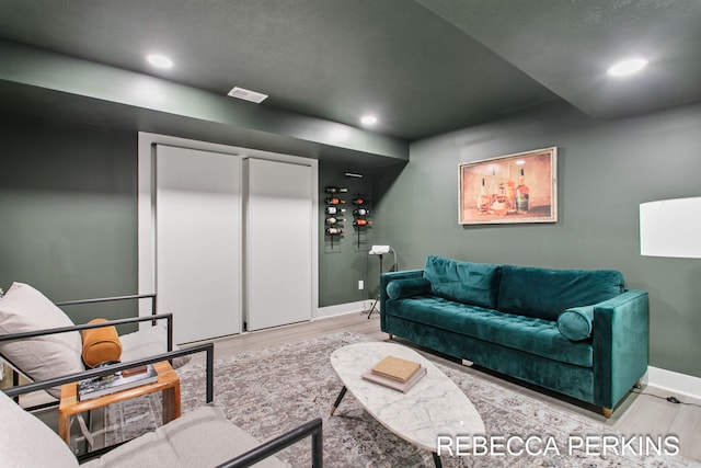 living area with wood finished floors, baseboards, and recessed lighting