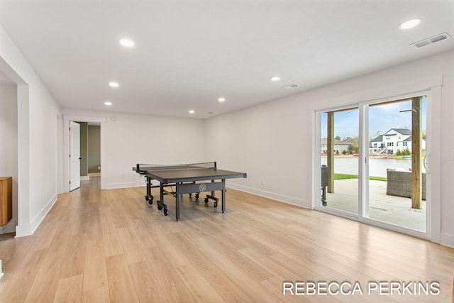 game room with a water view, light wood-style floors, recessed lighting, and baseboards