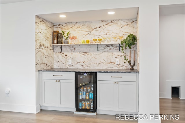 indoor dry bar featuring wine cooler, light wood finished floors, backsplash, baseboards, and recessed lighting