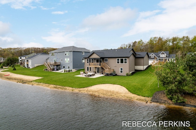 rear view of house featuring a water view, a patio, a lawn, and a residential view