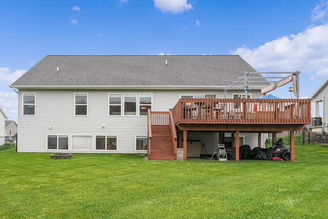 rear view of house with a wooden deck, a yard, stairs, and a shingled roof