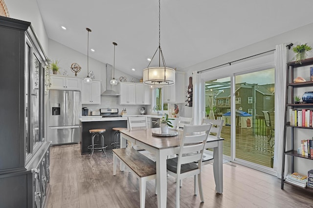 dining space featuring wood finished floors, plenty of natural light, recessed lighting, and high vaulted ceiling