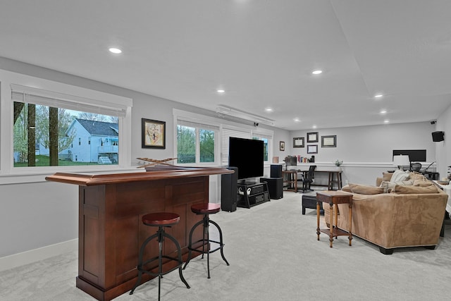 living area featuring light carpet, a bar, recessed lighting, an office area, and baseboards